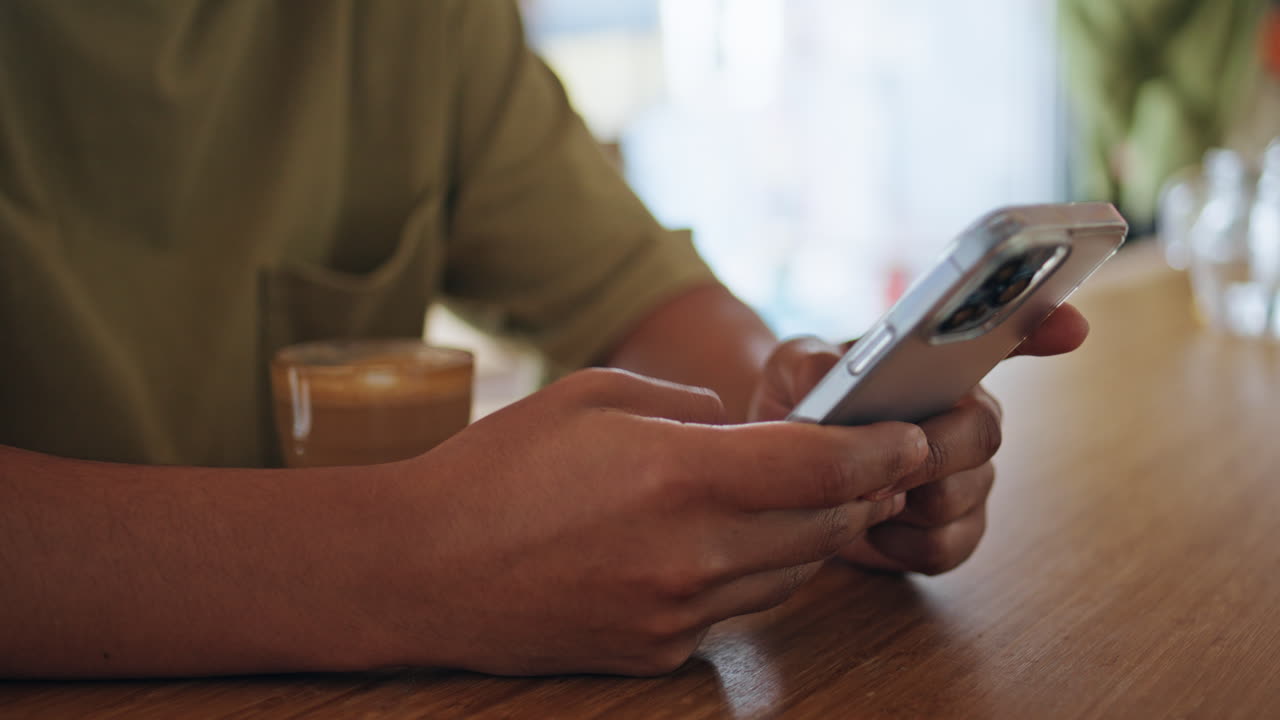 Man hands texting cellphone in cafeteria close up. Unknown man messaging in cafe