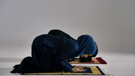 dos jóvenes musulmanas asiáticas con hijab tradicional están orando glorificen a alá y practicando la fe islámica en la mezquita.