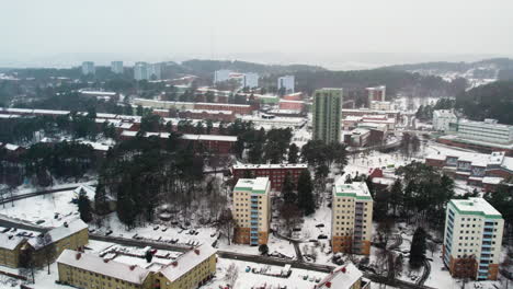 Winter-scene-of-Kortedala,-a-quiet-suburb-in-Gothenburg-with-snow-covered-buildings-and-trees,-overcast-sky