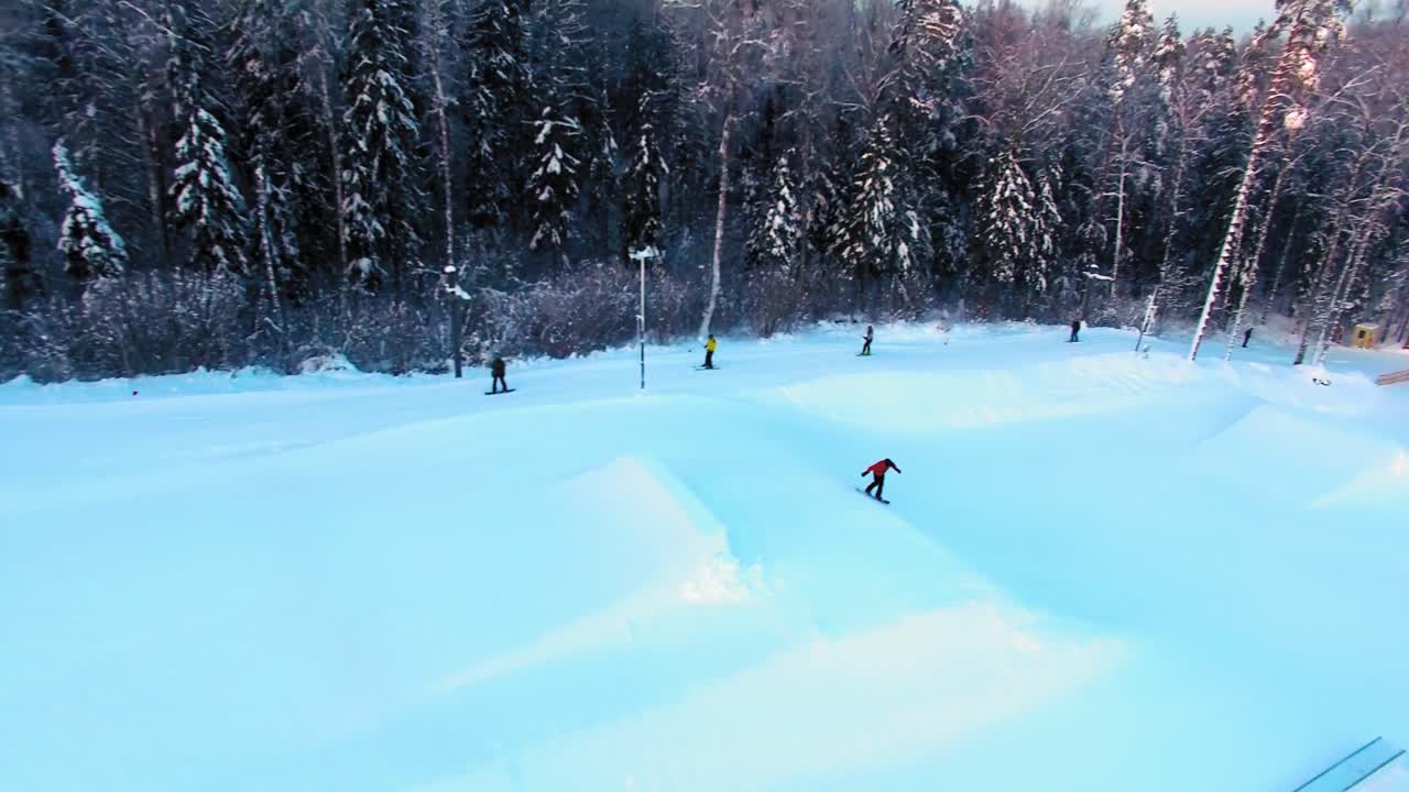 터레인 파크의 슬로프에서 뛰어내리는 스노보더의 측면 조감도