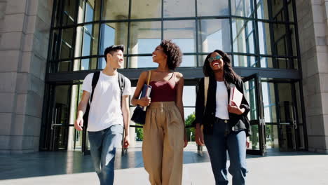 diverse students walking and talking outside a modern university building