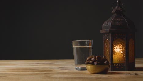 Toma-De-Seguimiento-De-Un-Agua-De-Linterna-Y-Fechas-En-Una-Mesa-Para-El-Ramadán