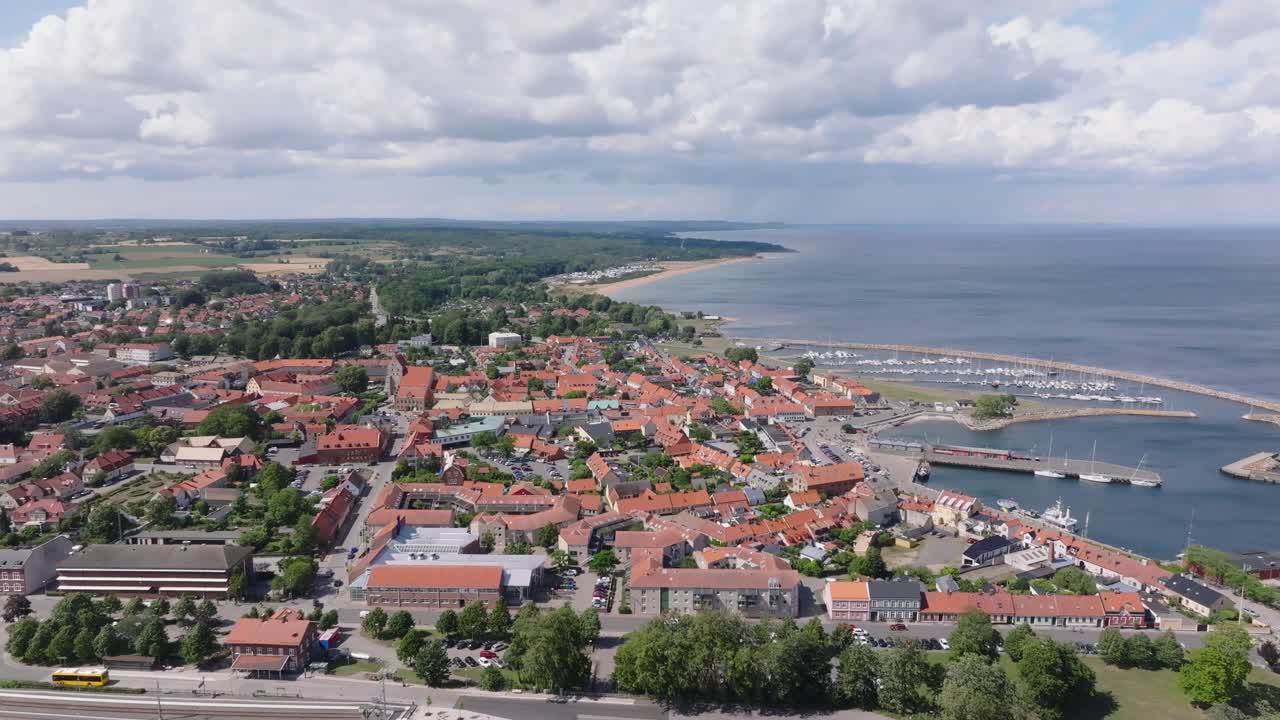 Ripresa aerea laterale sulla piccola città di Simrishamn in Svezia in una giornata di sole nuvolosa