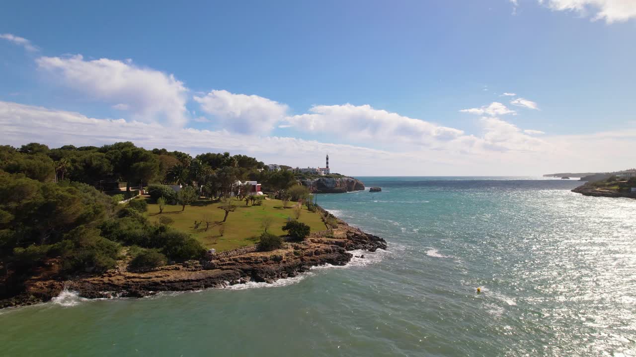 Drone flight over a bay towards the lighthouse