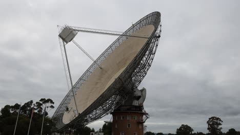gran antena de radio telescopio girando bajo un cielo nublado