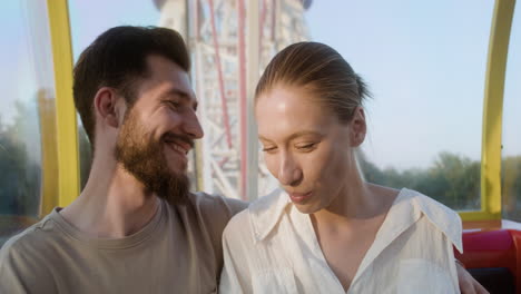 young couple eating popcorn on a ferris wheel