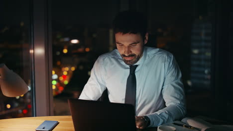male workaholic working late evening on laptop close up. businessman busy office