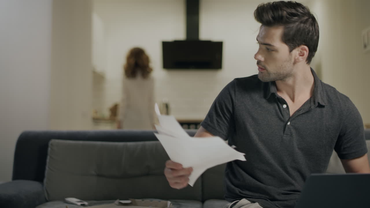 Serious business man working on laptop computer at home kitchen