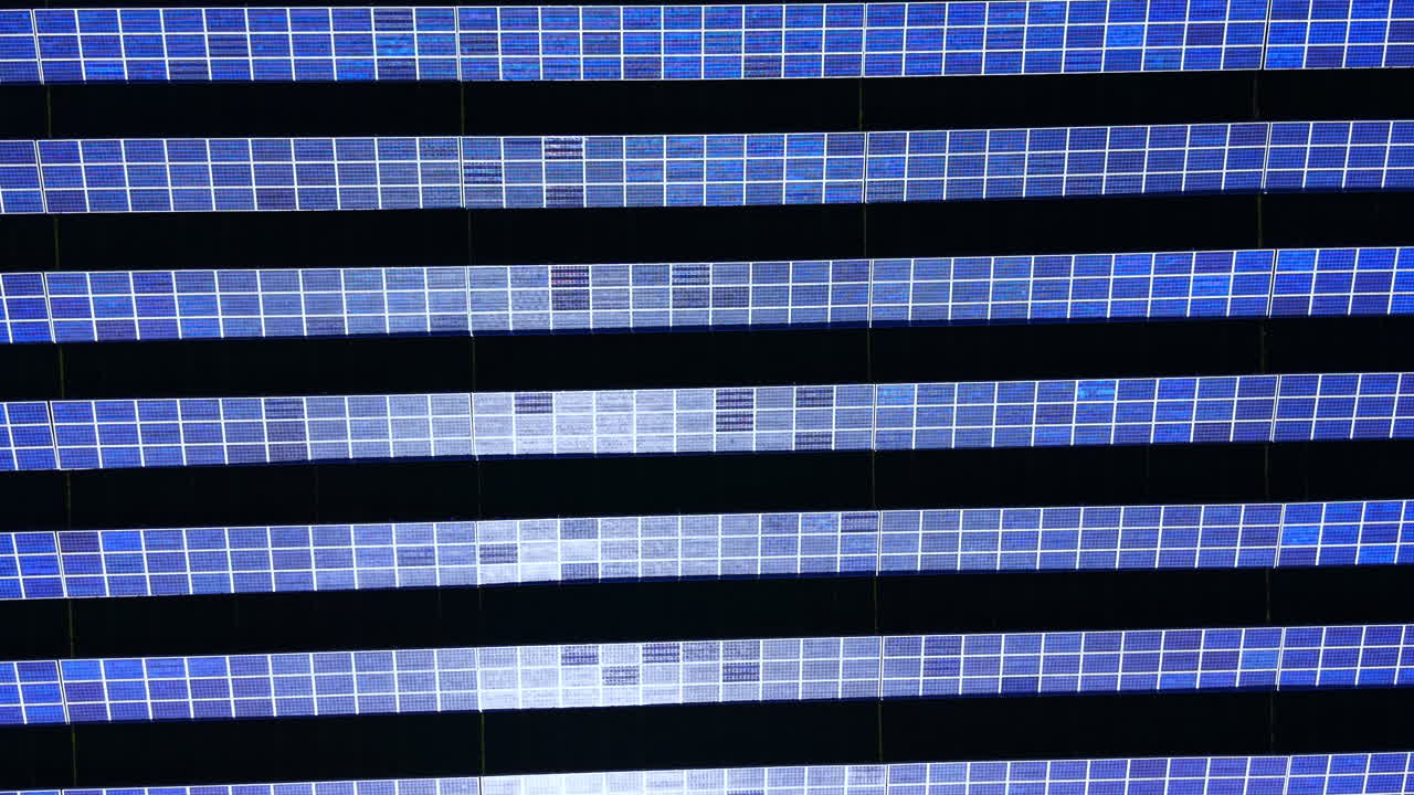 Linee fotovoltaiche blu parallele con dolci riflessi di luce solare sulla superficie. Motivo astratto di file di pannelli solari con bagliori di luce.