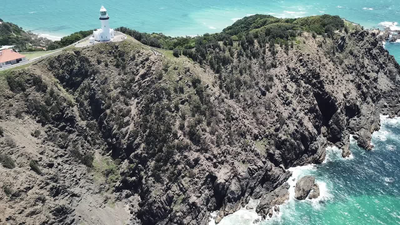 화창한 날에 등대를 보여주기 위해 패닝하는 아름다운 푸른 물 위의 드론 공중