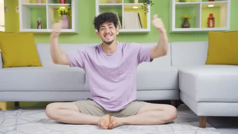 happy and excited young man experiencing joy at home looking at camera.