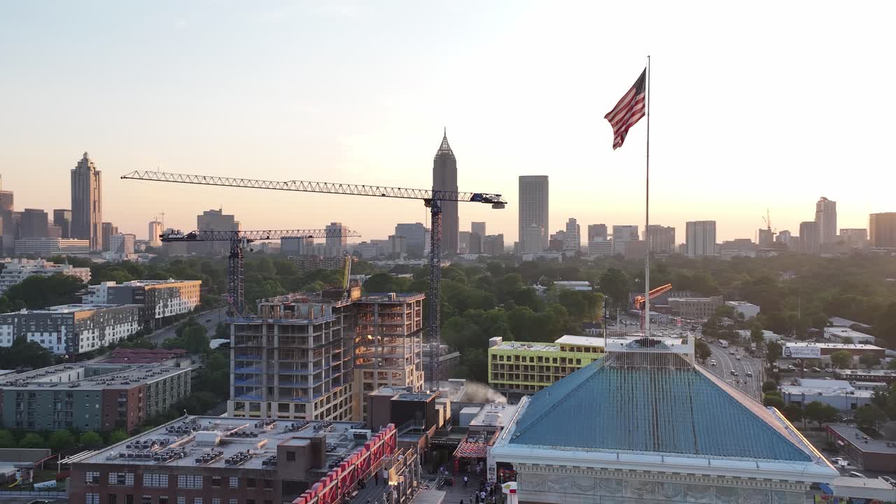 미국 조지아 주 애틀랜타의 초고층 빌딩을 배경으로 해가 지는 하늘을 배경으로 폰스 시티 마켓 타워 꼭대기에 있는 미국 국기