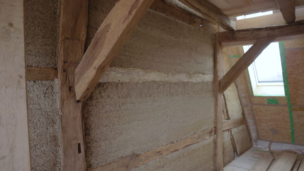 Diagonal zoom out of hempcrete wall in timber frame inside an attic during construction