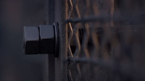 Closeup-metal-mesh-netting-in-sunlight.-Iron-two-hex-nuts-for-constructing.