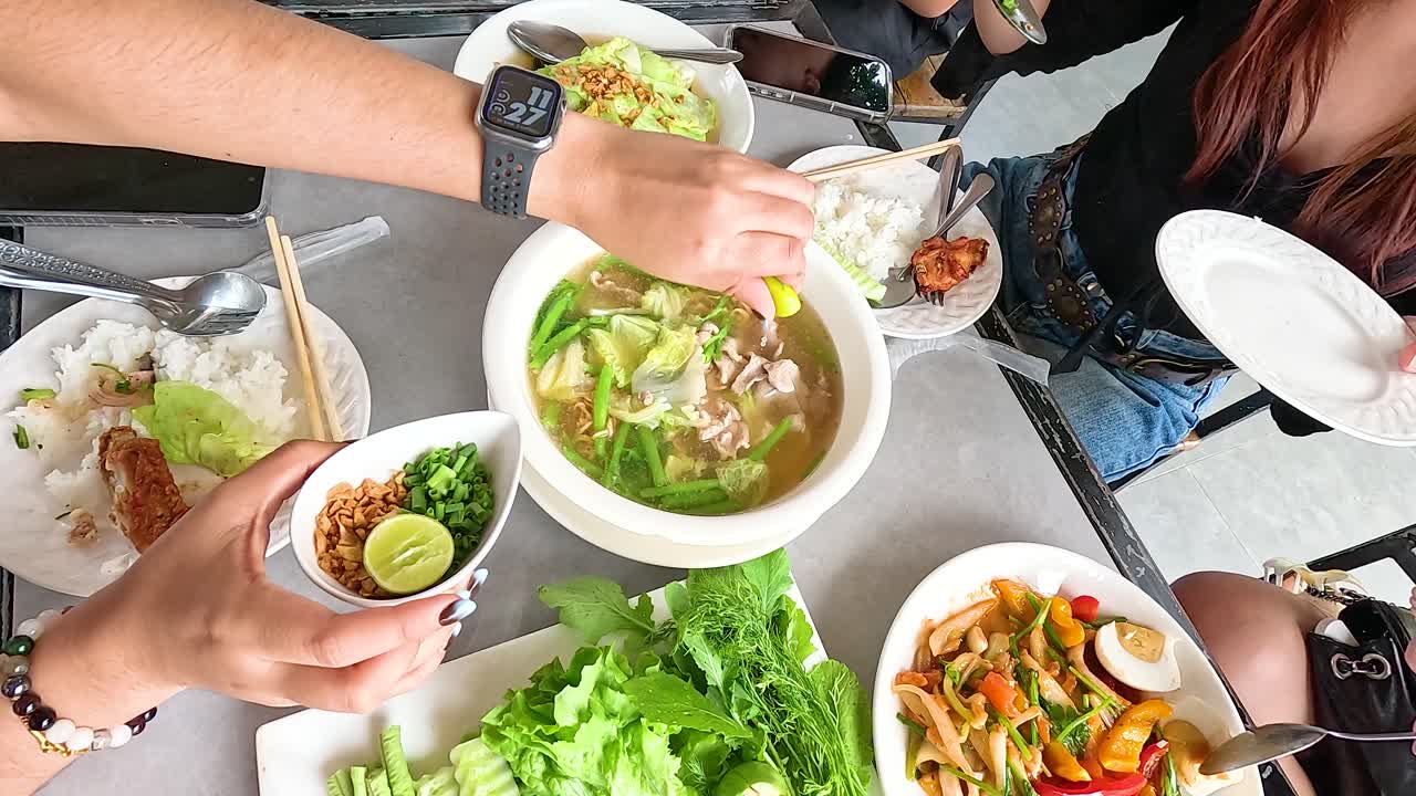 A vibrant meal in Champasak, Laos, showcasing traditional dishes with fresh ingredients. Captures communal dining and cultural richness