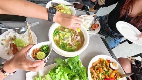 a vibrant meal in champasak, laos, showcasing traditional dishes with fresh ingredients. captures communal dining and cultural richness