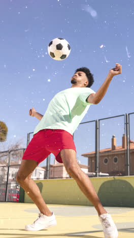 young man playing and resting with a soccer ball on an outdoor court