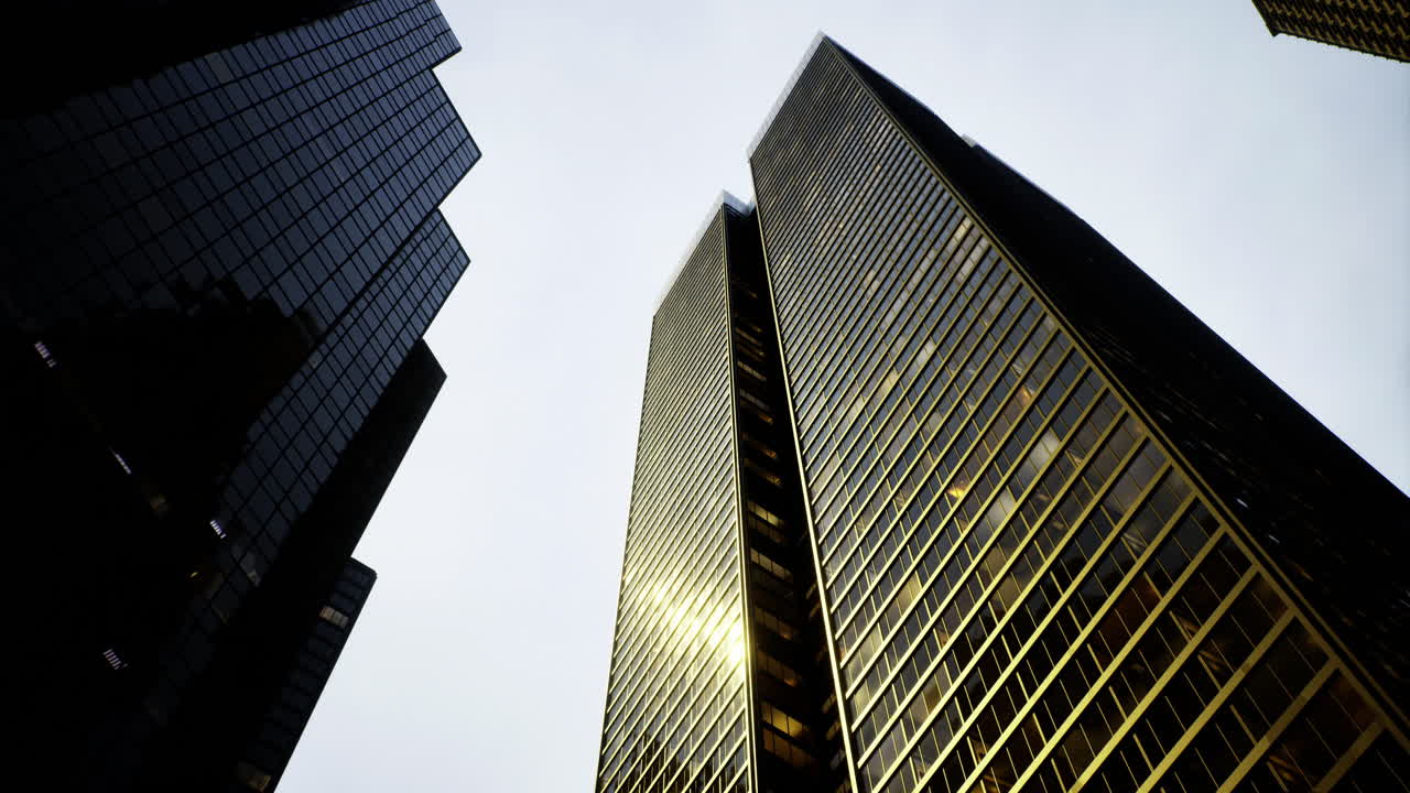 Tall glass skyscrapers reflecting light in an urban skyline during twilight
