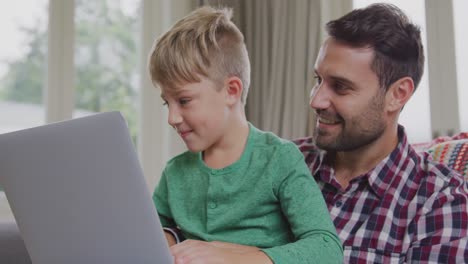 Padre-E-Hijo-Usando-Una-Computadora-Portátil-En-Un-Hogar-Cómodo-4k