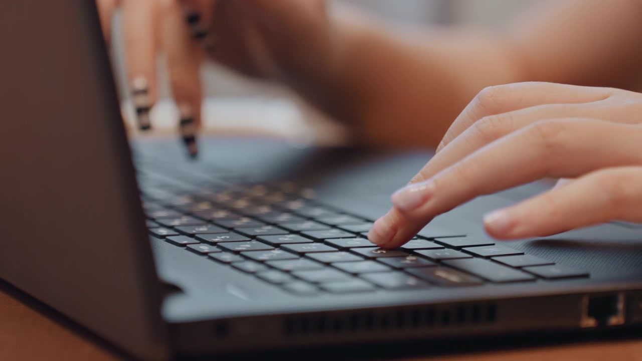 Polpastrelli sulla tastiera che modificano. Mani eleganti sullo schermo del laptop. Beauty blogger che lavora con unghie curate. Primo piano di unghie e dita mentre la blogger modifica e programma contenuti per i social media