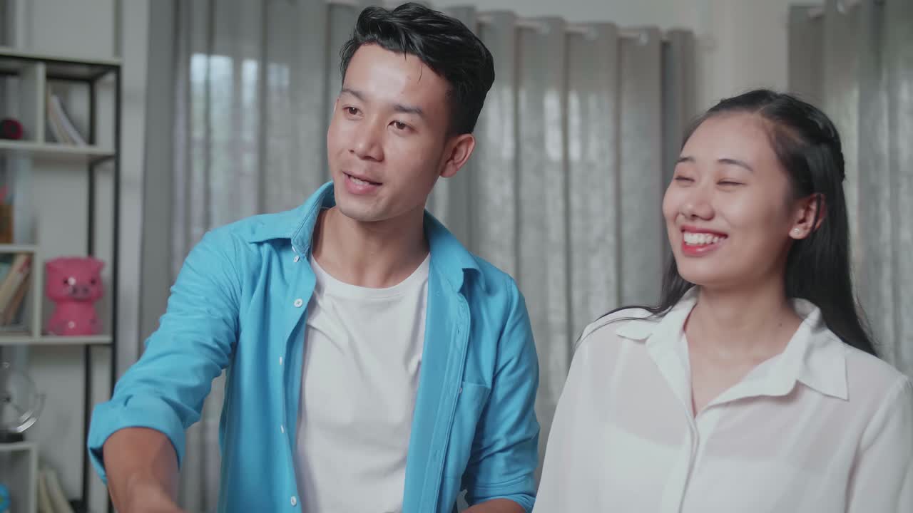 아시안 남자가 열를 받고 부동산 대리인과 손을 흔들면서 판매 중인 집에 있는 여자와 함께 서 있습니다.