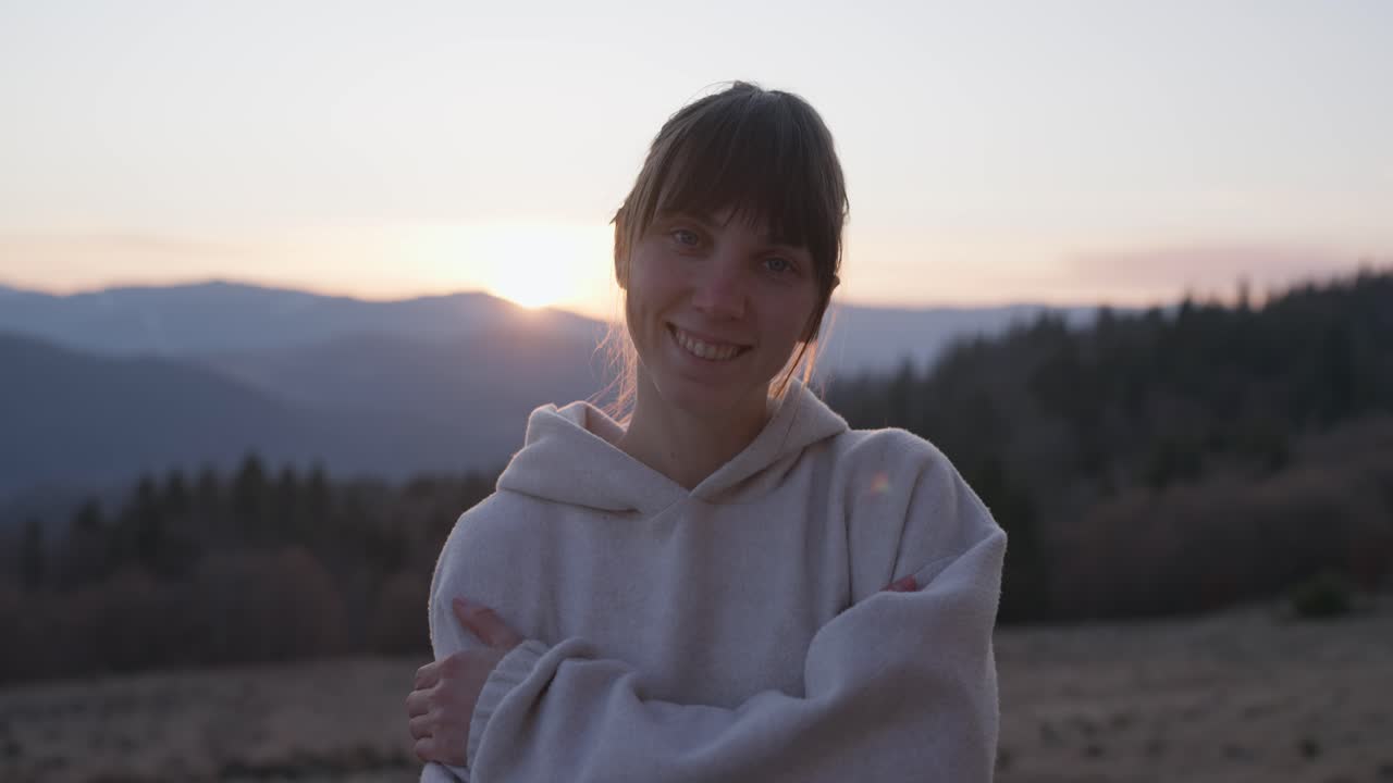 Woman smiling in front of mountain sunset