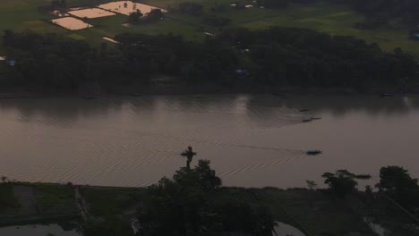 fisherman boats in surma river at evening in rural countryside of bangladesh