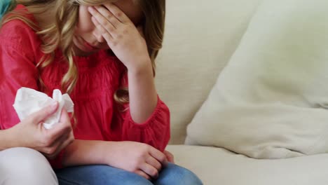 Mother-consoling-her-daughter-in-living-room