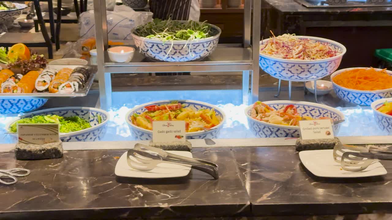 잘 조명 된 뷔페 환경에서 다채로운 요리 배열, 태국 레스토랑에서 다양한 요리 제공을 보여줍니다.