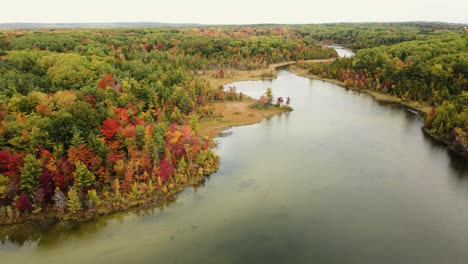 small lake in early autumn with changing leaves