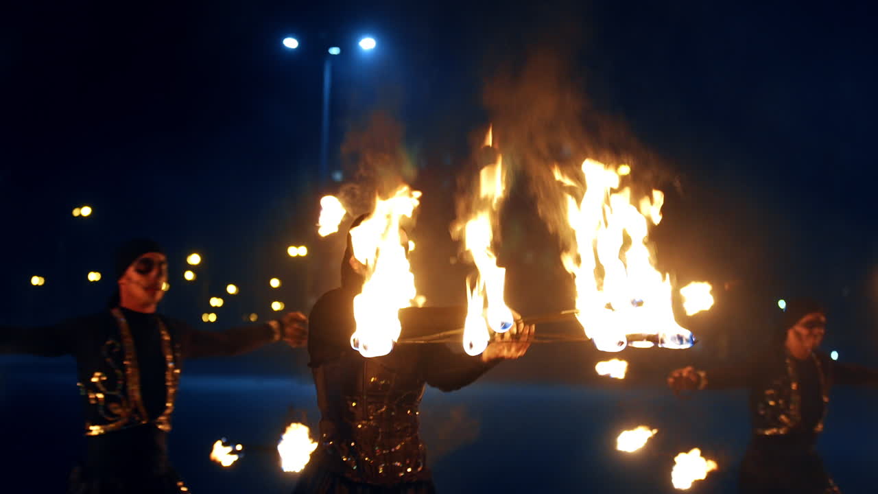 Dancing with fire. Group of artists perform their show at night. Beautiful fire spectacle outdoors.