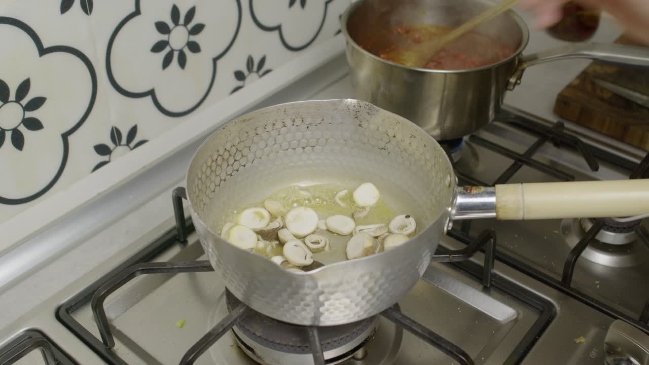 Chef adds mushrooms into cooking pot with boiling butter