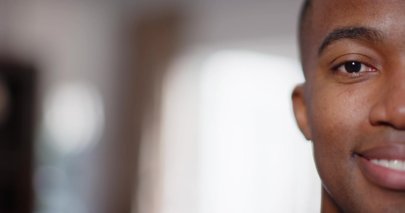 African American man reacting and smiling to off-camera joke in hallway arched window, copy space