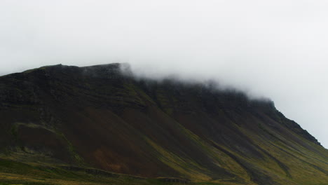 white clouds rolling over mountain peak in iceland, zoom in view