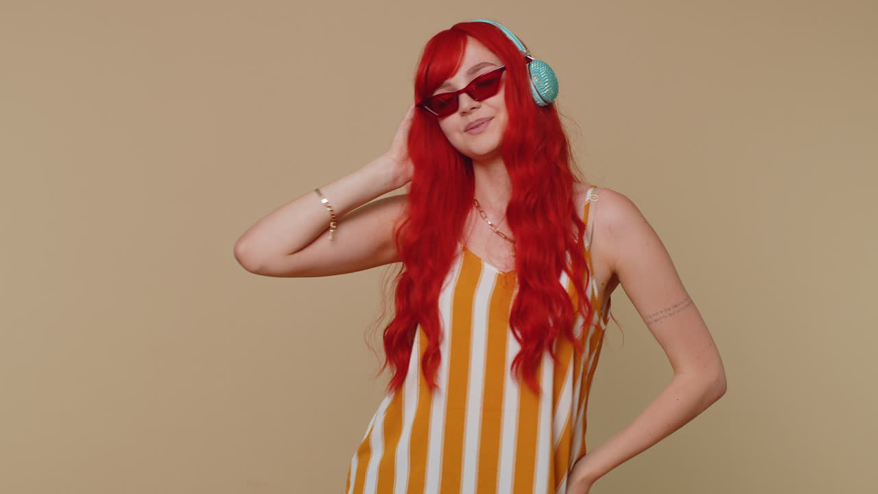 쾌활한 은 머리 여성이 헤드폰을 통해 음악을 듣고 댄스 디스코를 즐기며 놀고 있습니다.