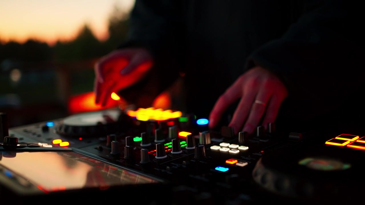 DJ mixer musik på controller ved solnedgang