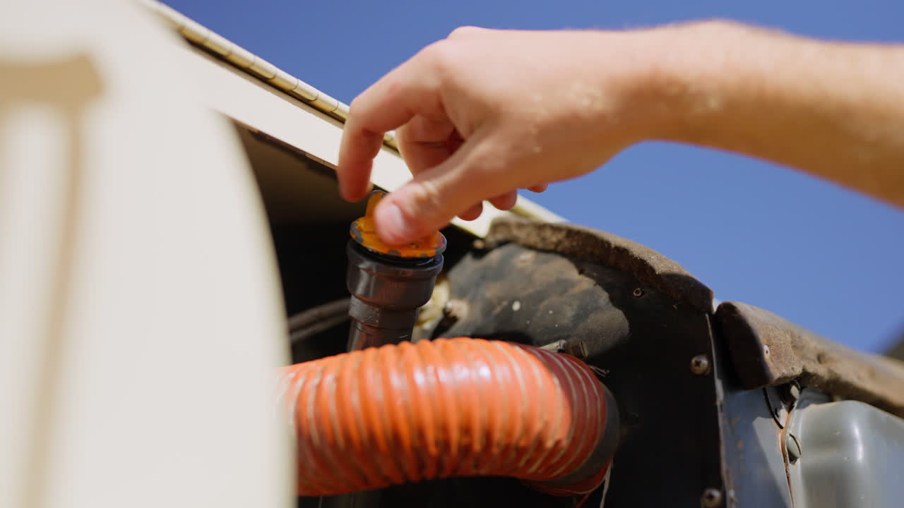 Primo piano di una mano che controlla il livello dell'olio motore con l'astina di livello