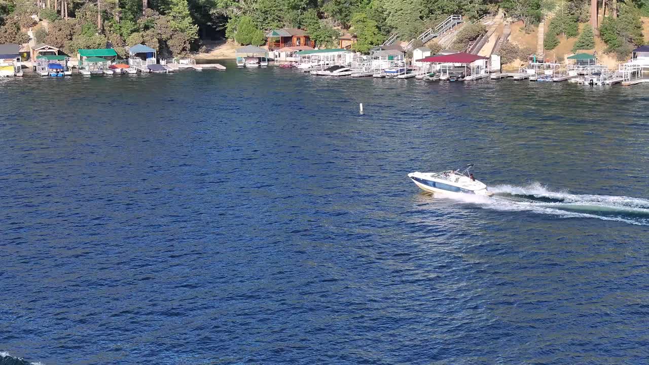 siguiendo un bote de velocidad lado a lado en el lago arrowhead en california en un brillante día soleado transporte aéreo siguiendo