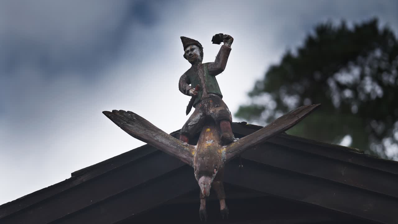The whimsical statue of a gnome figure riding a bird decorates the rooftop, adding charm to the building’s design.