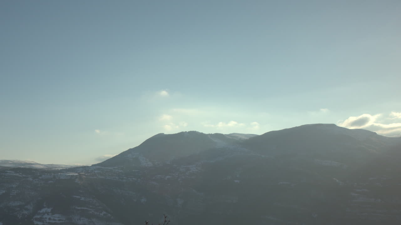 Cinematic drone panorama of majestic snow-covered mountain at golden hour, alpine wilderness evoking adventure, exploration, skiing, snowboarding, extreme sports, winter travel, and cinematic beauty