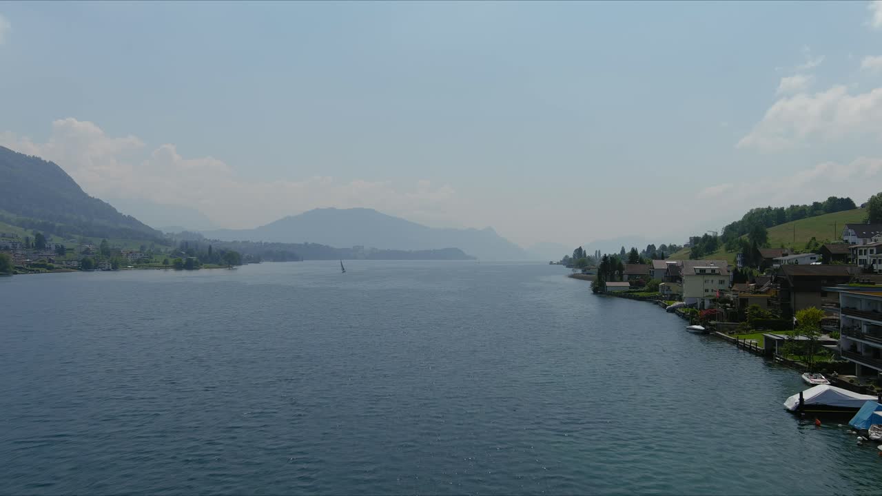 쿠스나흐트 플라이오버: 알프스 산맥의 경치 좋은 물 계곡과 마을을 가로질러 이동, 스위스, 유럽, 드론 | 넓은 호수와 시골과 함께 마을 도시에서 도크의 극적인 영화 플라이오버