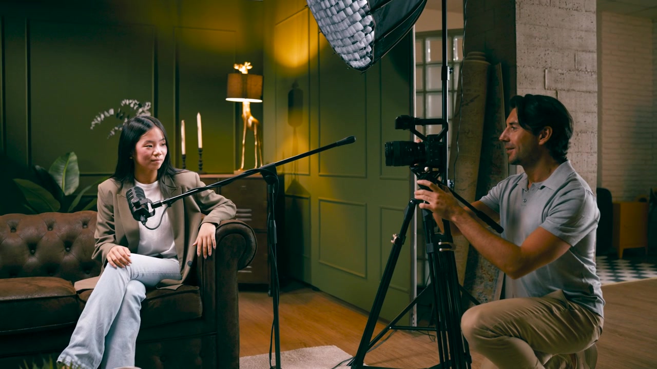 Videographer Filming an Interview with a Woman in a Studio