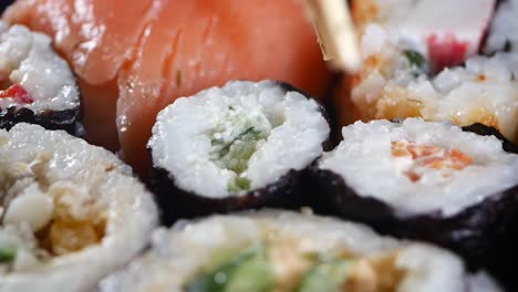 a plate of assorted sushi rolls with salmon, cucumber and shrimp