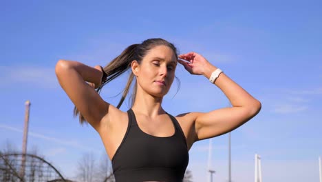 atractiva mujer atlética atando el cabello antes de correr a cámara lenta