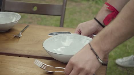 disparo recortado de personas sirviendo mesa al aire libre