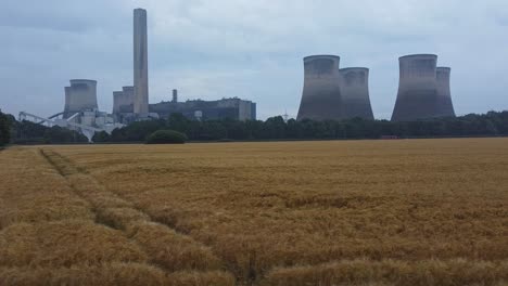 imposing concrete cooling tower power station farmland countryside aerial view low angle dolly right