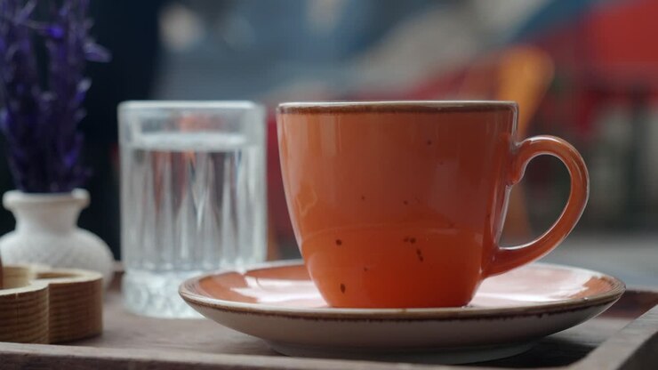 Primo piano di una tazza di caffè turco su un vassoio con un bicchiere d'acqua.