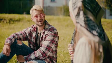 man wearing sunglasses talking with friends during picnic