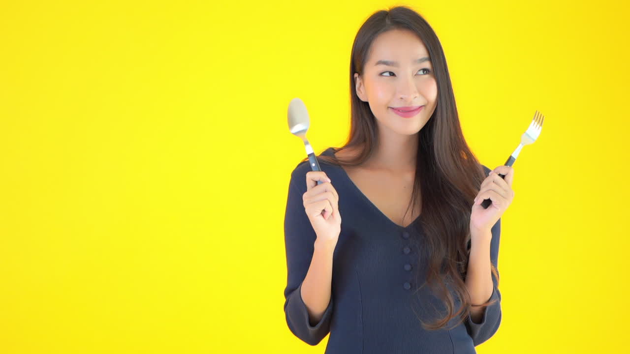 Bon appetit asian woman posing with cutlery