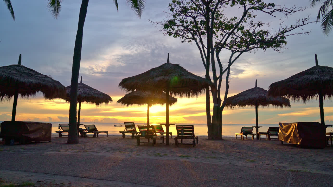 sombrilla y silla en la playa tropical con amanecer en la mañana